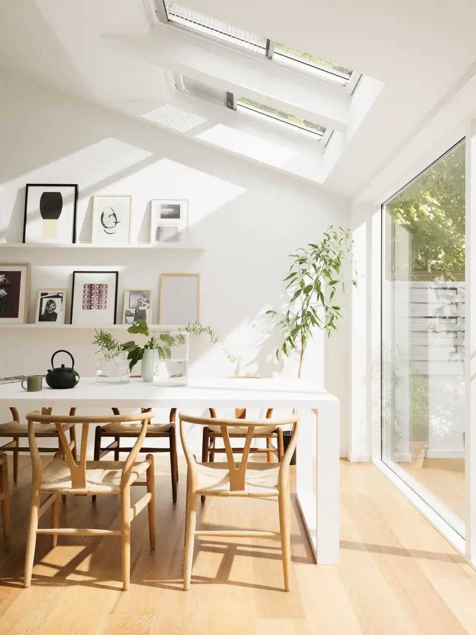 salle à manger lumineuse avec table en bois et fenêtres de toit VELUX équipées de stores vénitiens 