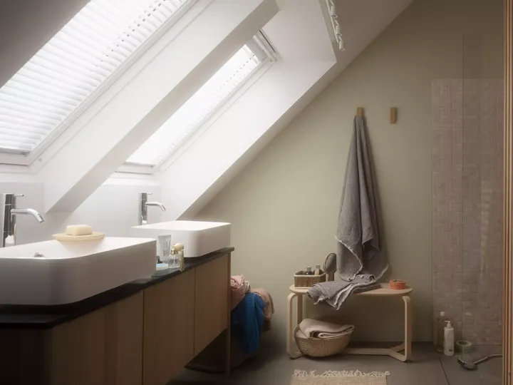 Badezimmer im Dachboden mit natürlichem Licht von VELUX Dachflächenfenstern, Doppelwaschtisch und begehbarer Dusche.