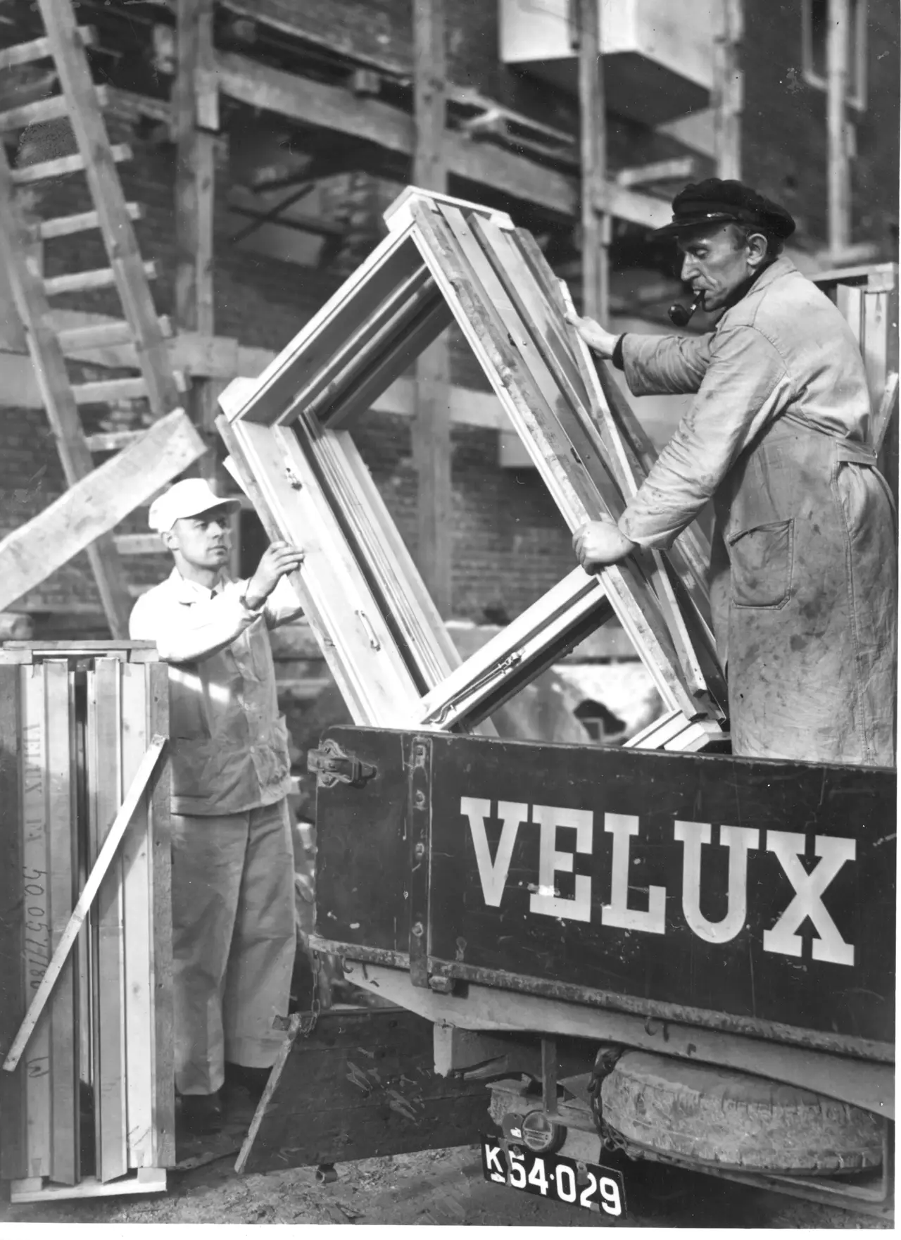 Arbeiter montieren ein VELUX Dachflächenfenster auf einer Baustelle.