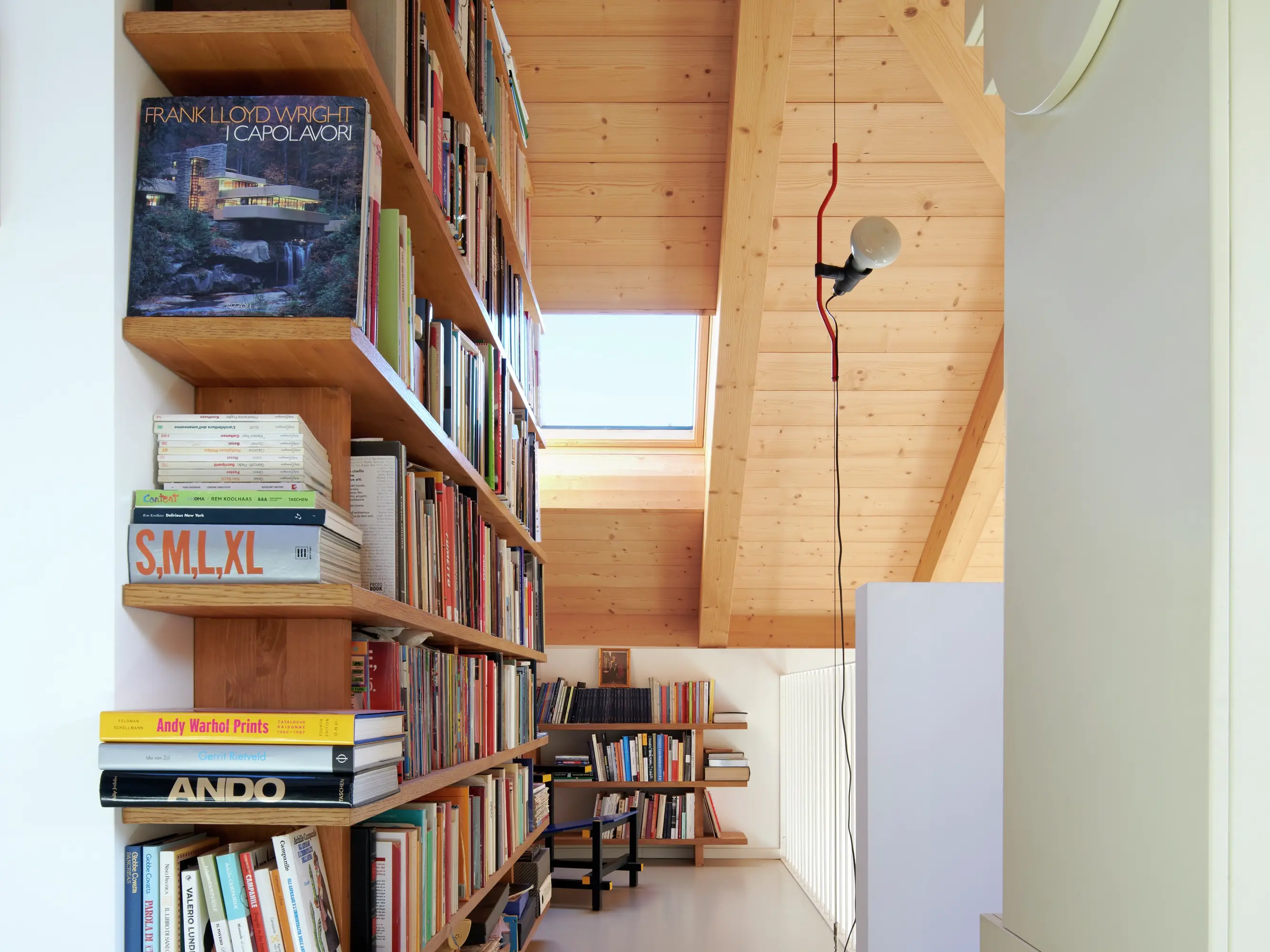 Bibliothèque à domicile avec étagère à livres en bois, murs en pin et une fenêtre de toit VELUX.