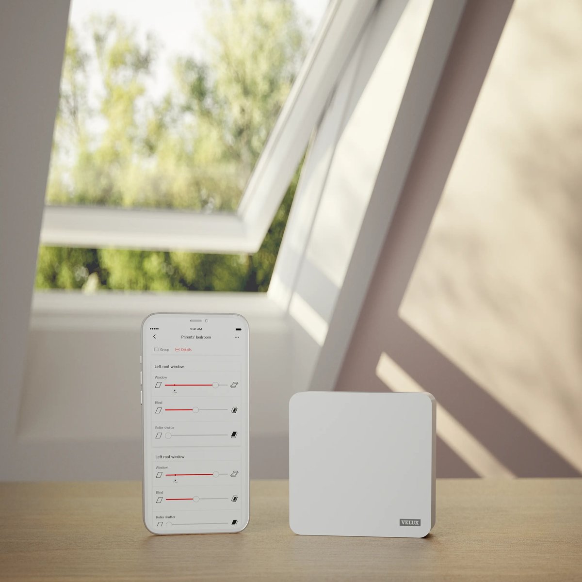 VELUX roof window open with smart control device and app in attic room.