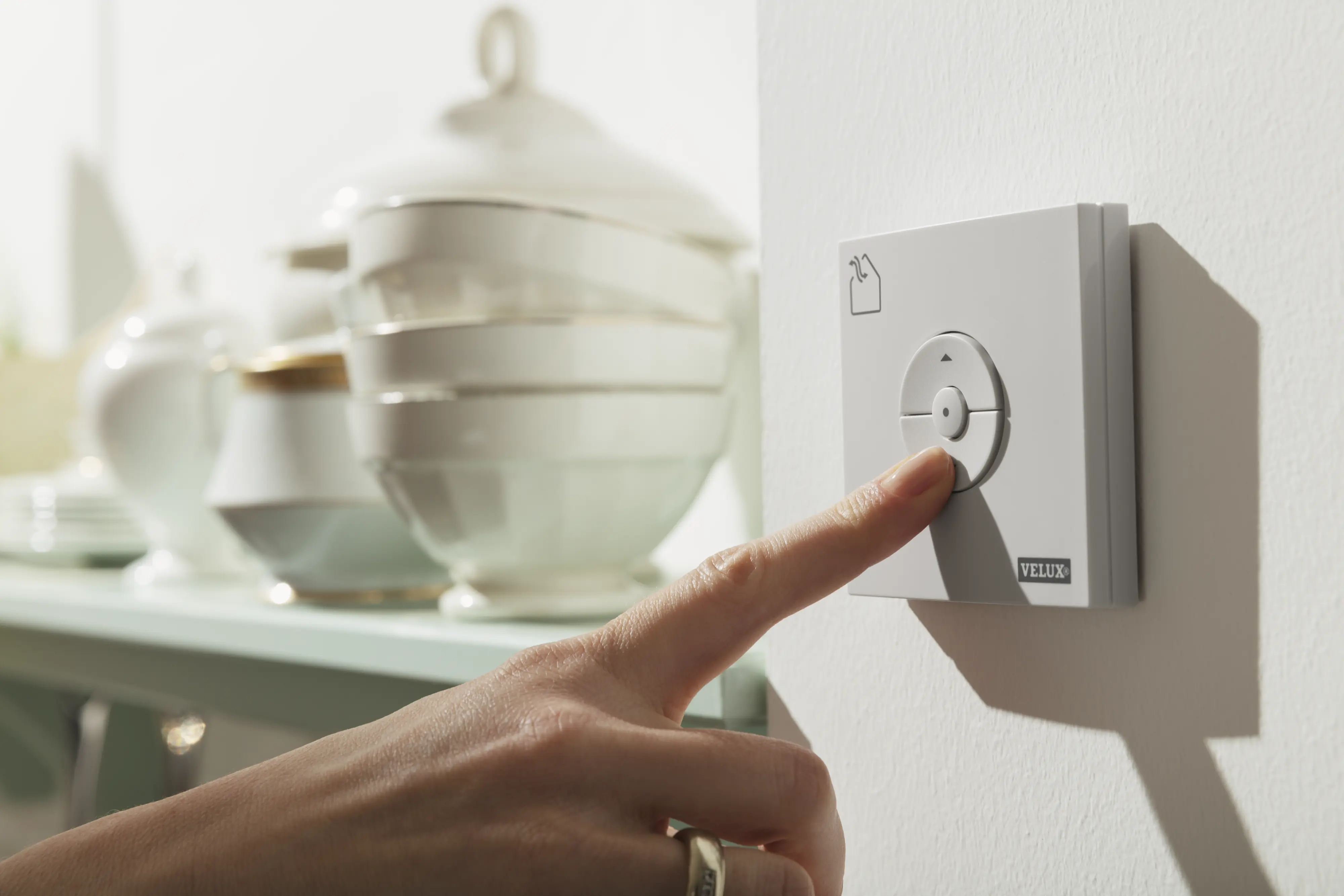 Ručne stlačené tlačidlo diaľkového ovládača VELUX v kuchyni.