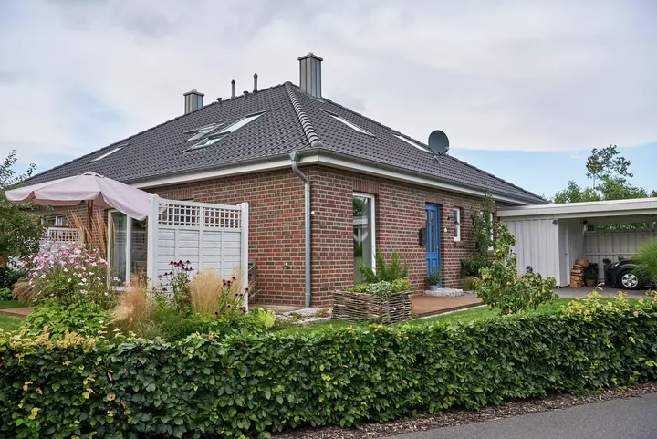 Einfamilienhaus aus Ziegelstein mit VELUX Dachflächenfenster, Garten und Terrasse.