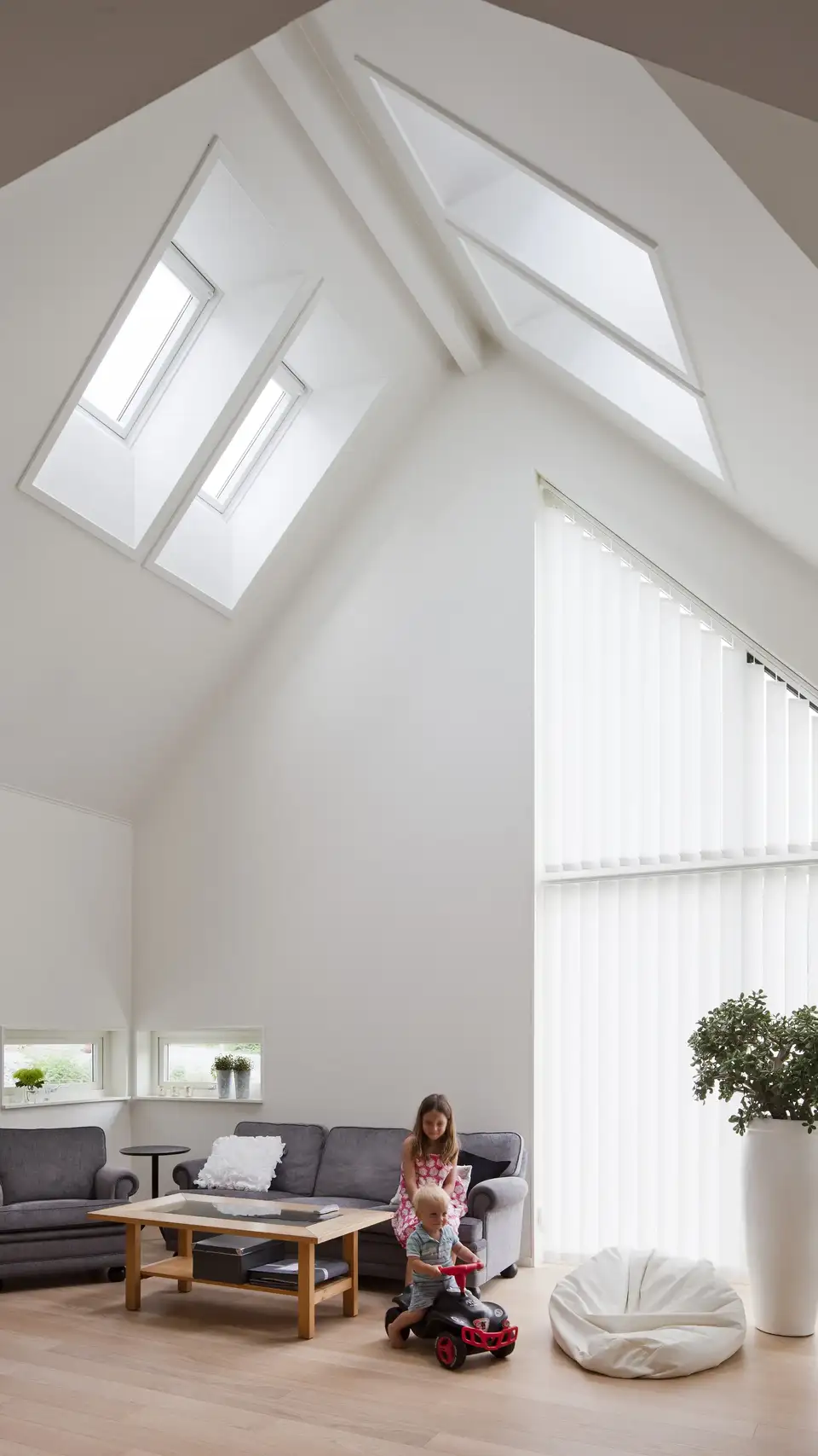 Soggiorno con soffitto alto e quattro finestre per tetti VELUX installate nella parte alta del tetto 