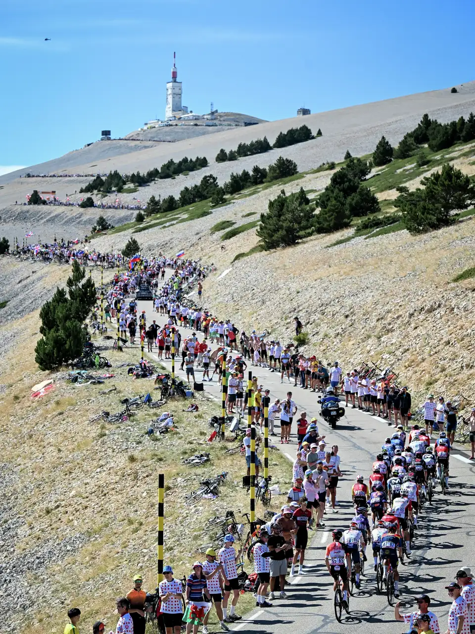 Колоездачи се изкачват по Мон Ванту, а зрители от Tour de France са наредени по пътя. 