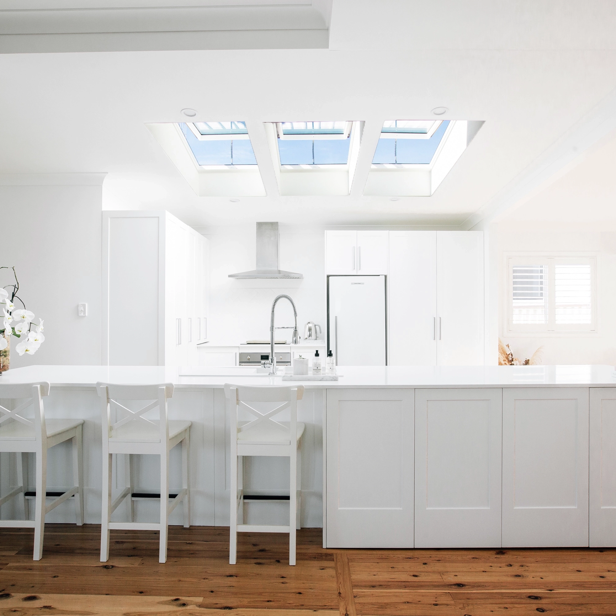 Bright kitchen with skylights and white cabinetry.