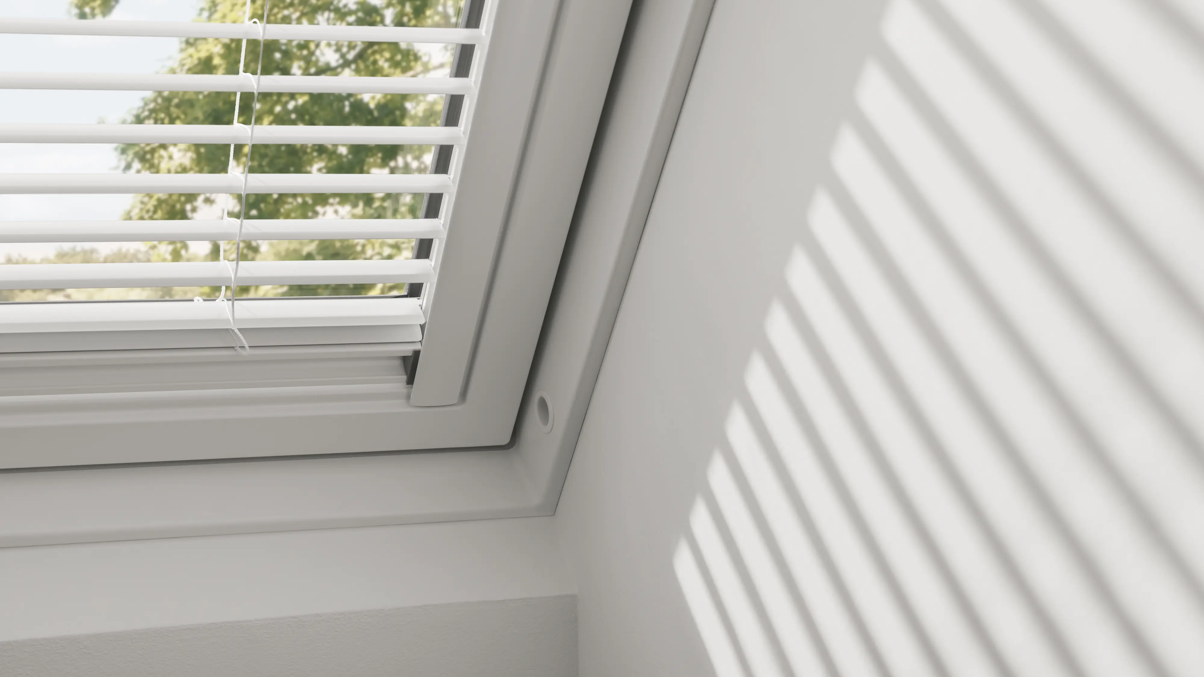 store vénitien VELUX avec lamelles ouvertes installé sur une fenêtre de toit compatible