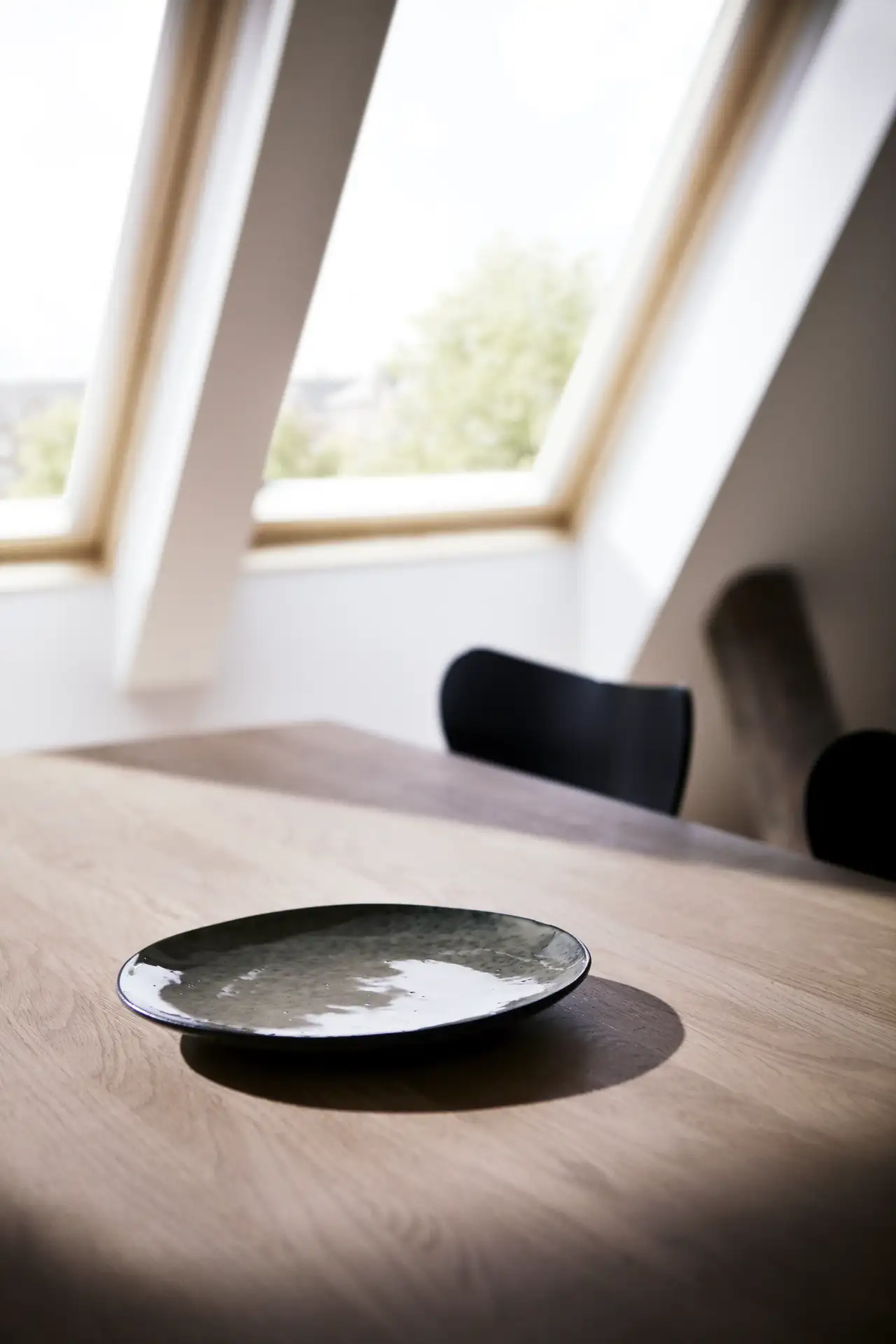 Dunkler Steingutteller auf Holztisch in Eichenoptik | VELUX Magazin