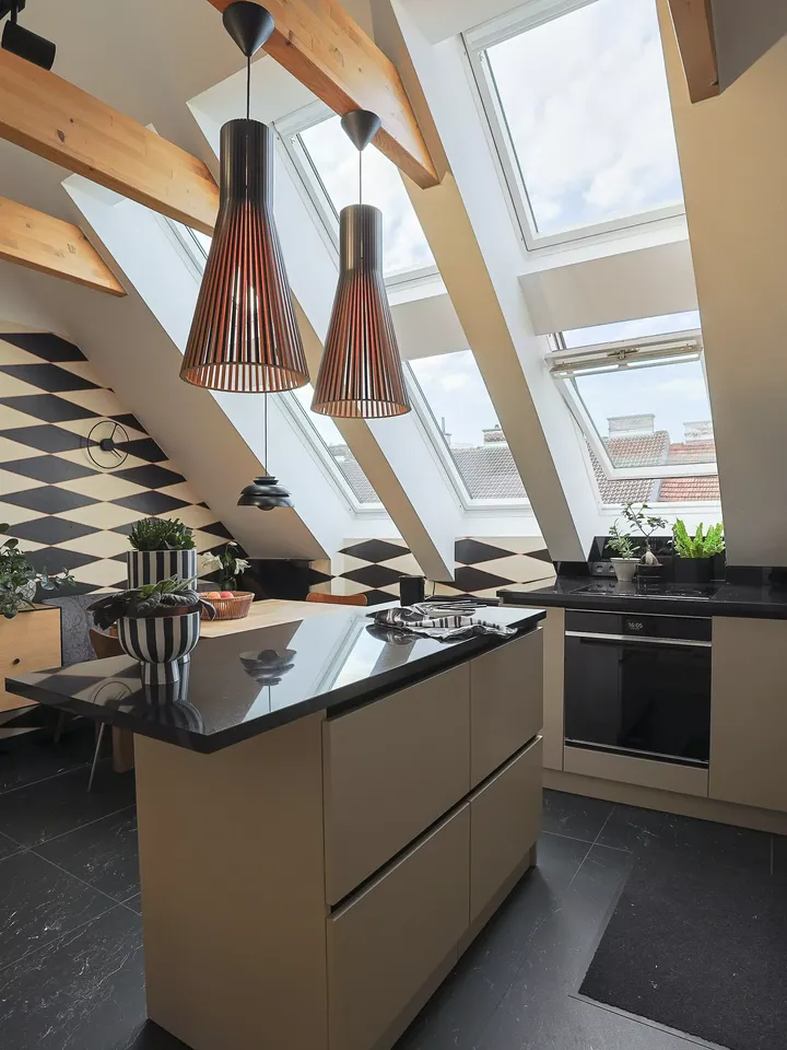Küche mit Kochinsel und Designlampen glänzt mit optimaler Farbwirkung in Schwarz-Beige | VELUX Magazin