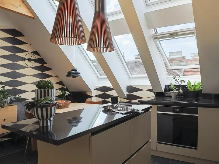 Moderne Küche mit geometrischem Wanddesign und VELUX Dachflächenfenster.
