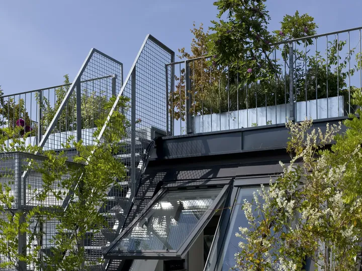 Modernes Gebäude mit grüner Dachterrasse, Metallgeländer und VELUX Dachflächenfenster.
