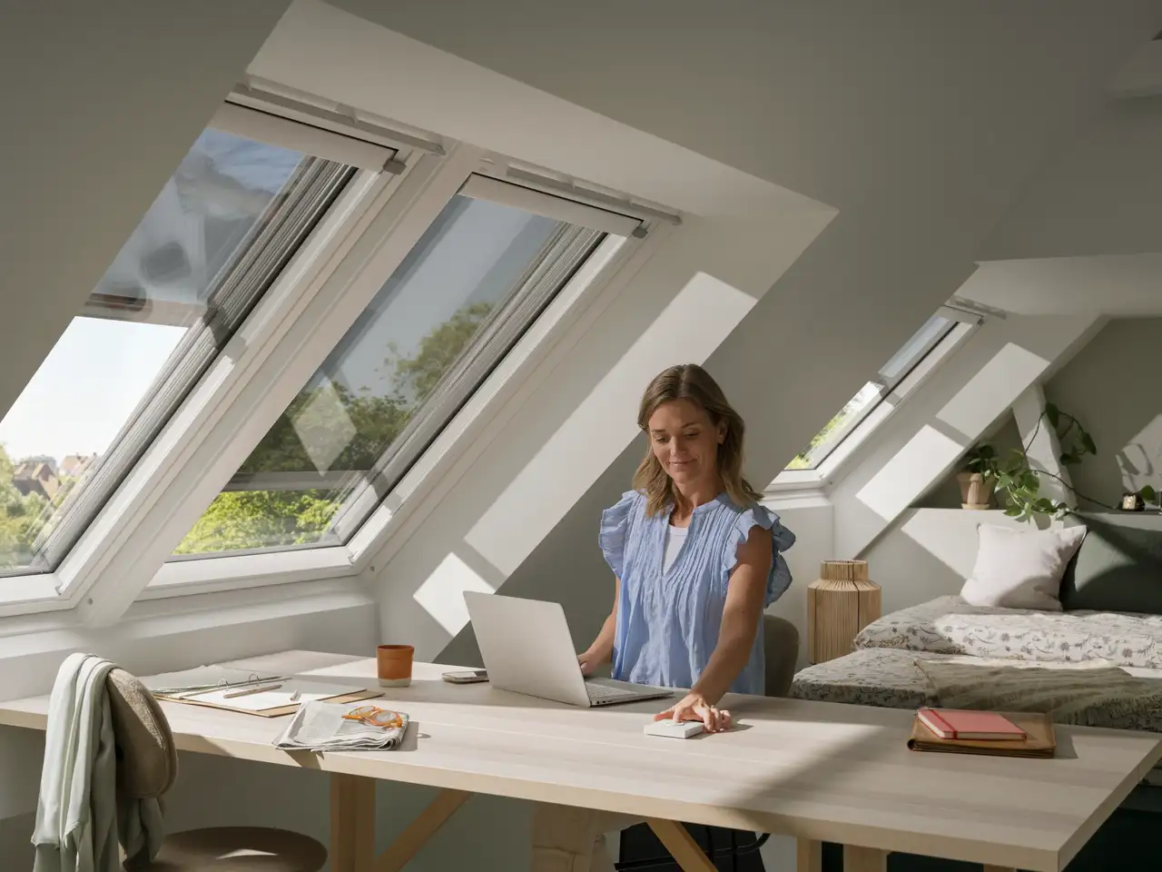 Attic room with woman, VELUX roof windows, awning blinds and wall switch, dining and sleeping areas, natural light.