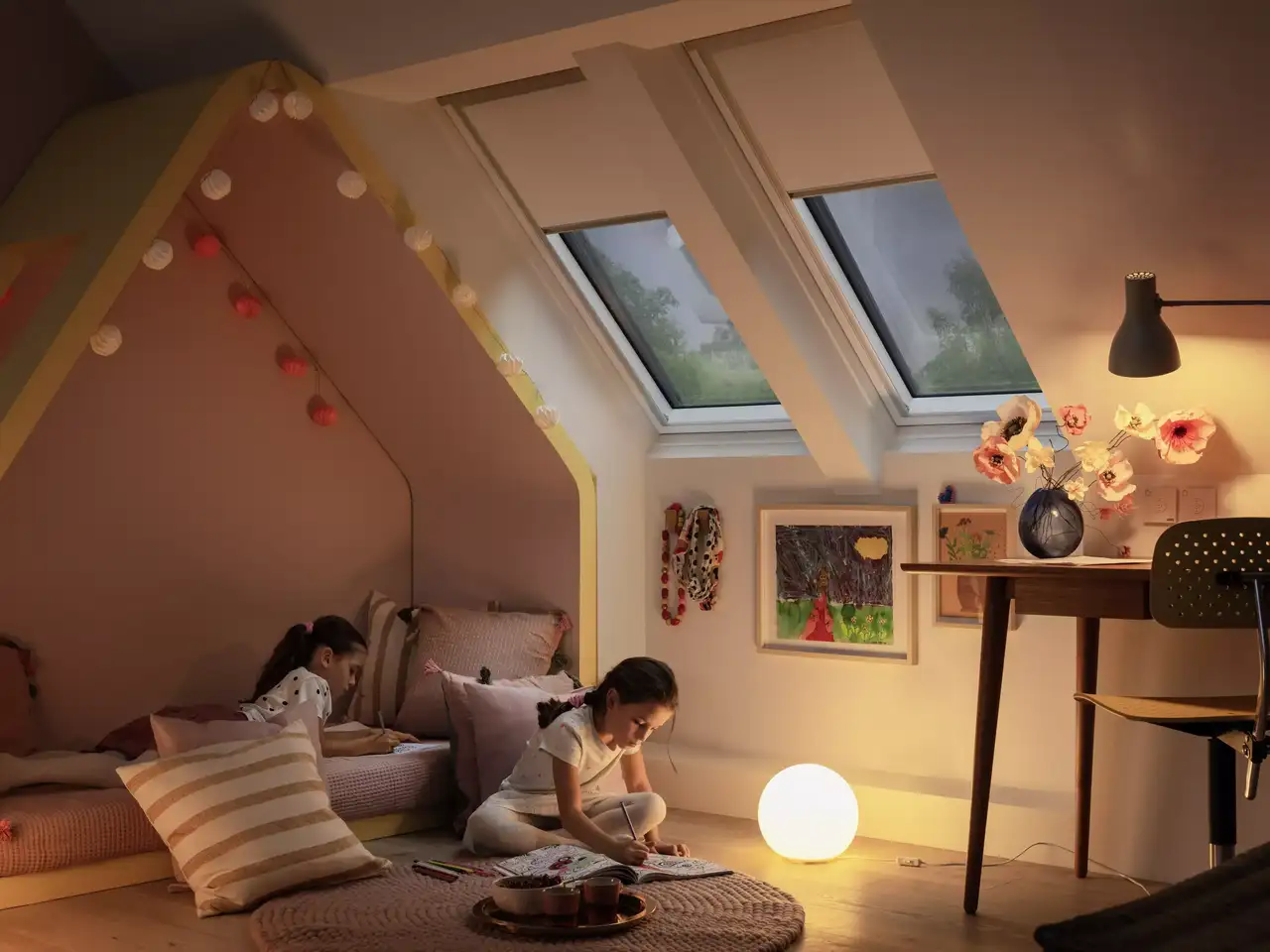 Attic kids room with sloped ceiling, VELUX roof windows, and playful decor.