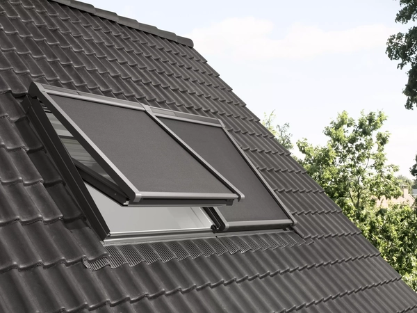 Roof with dark tiles and a partially open VELUX window.
