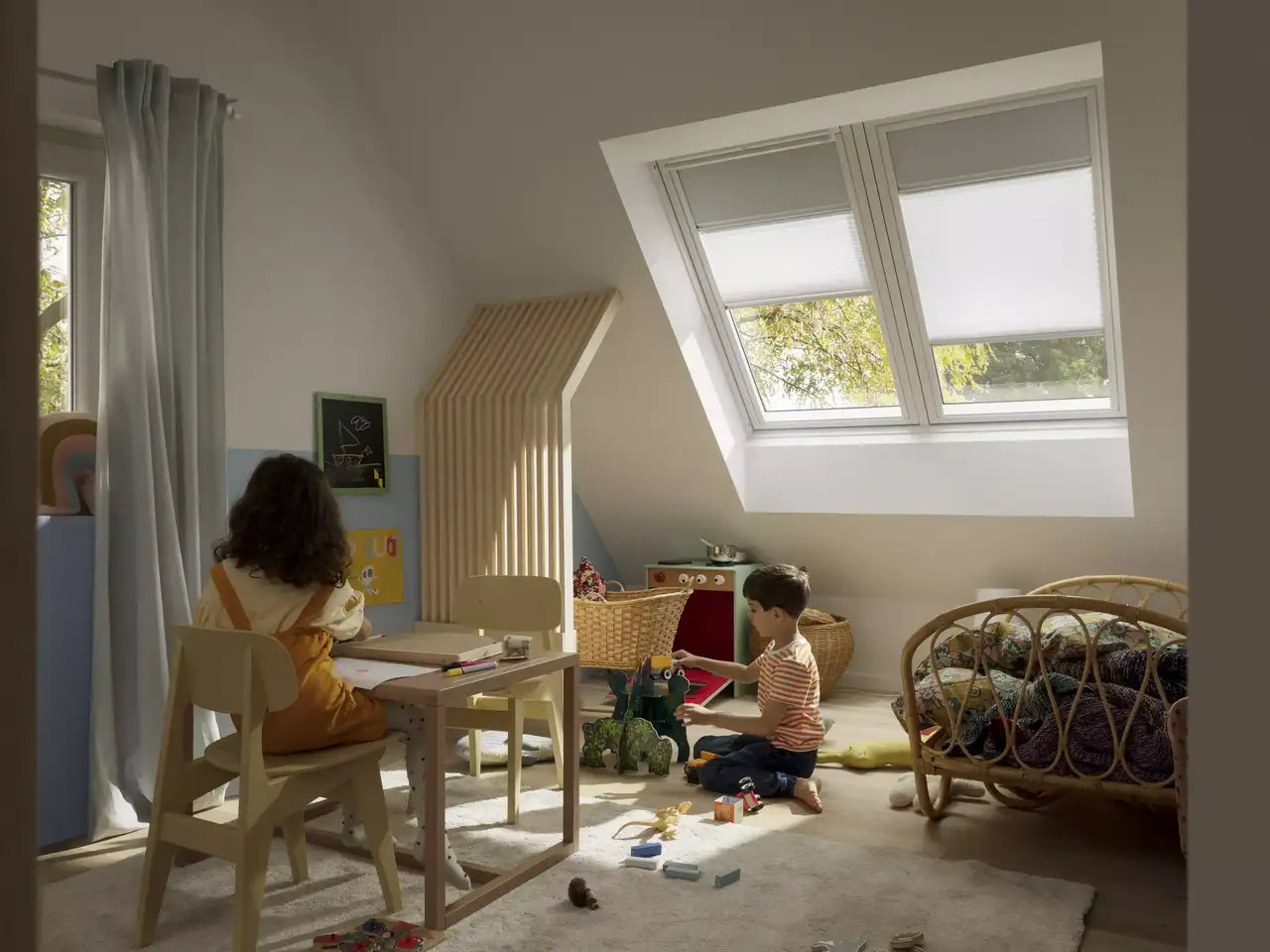 Kids room with sloped ceiling and large roof windows, toys and furniture.